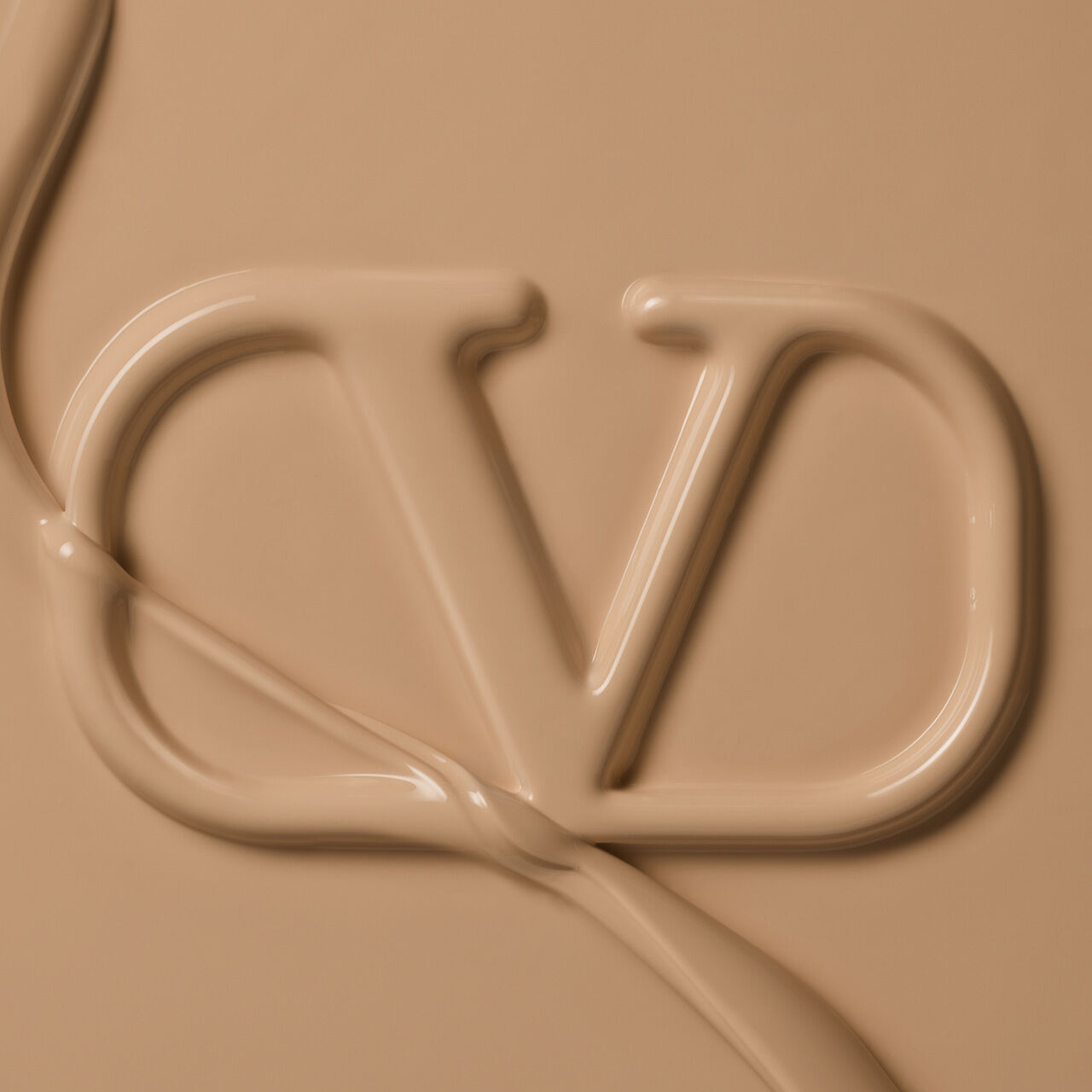 Close-up of a creamy, beige substance forming the letters "CD," resembling a cosmetic product.