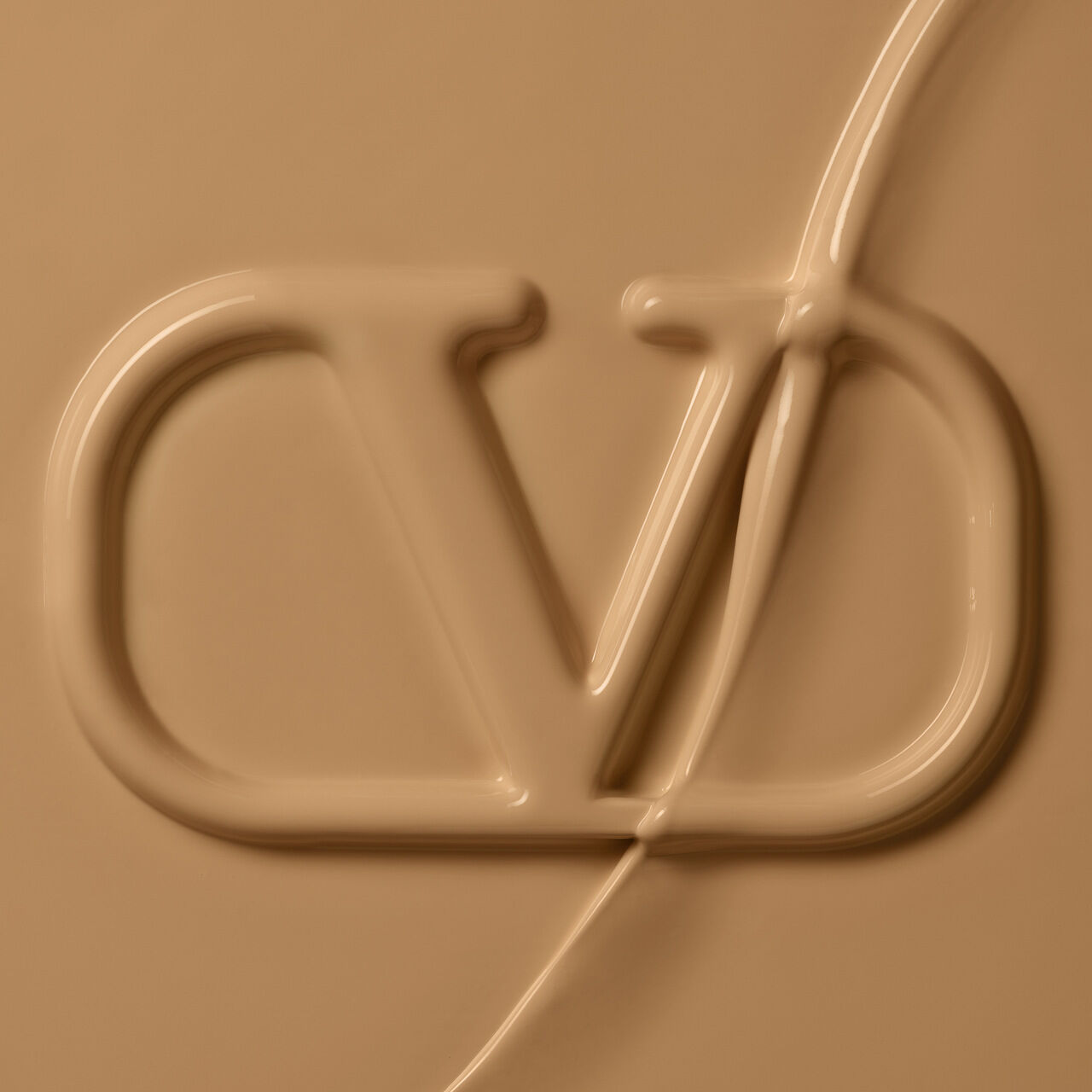 Close-up of a smooth, creamy surface featuring an embossed logo with stylized letters "C" and "D." The background is a warm beige color.