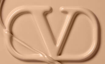 Close-up of a creamy beige substance forming the letters "VD," with a smooth, flowing texture.
