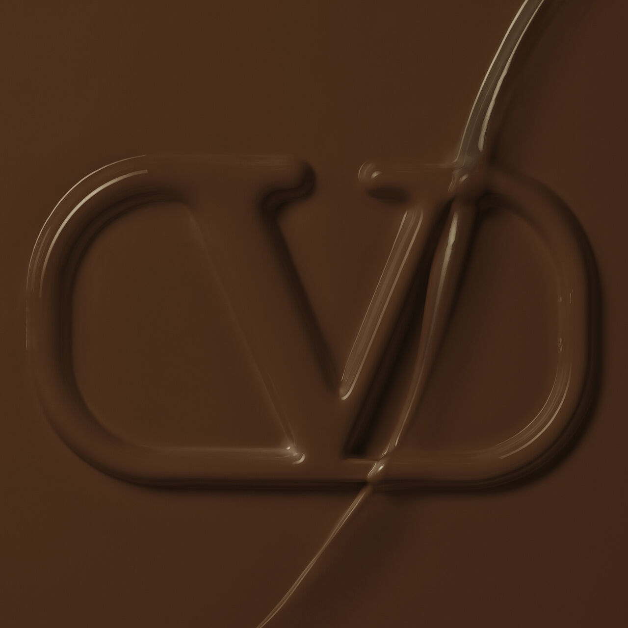 A smooth, dark brown surface featuring an embossed logo that resembles the letters "VD."