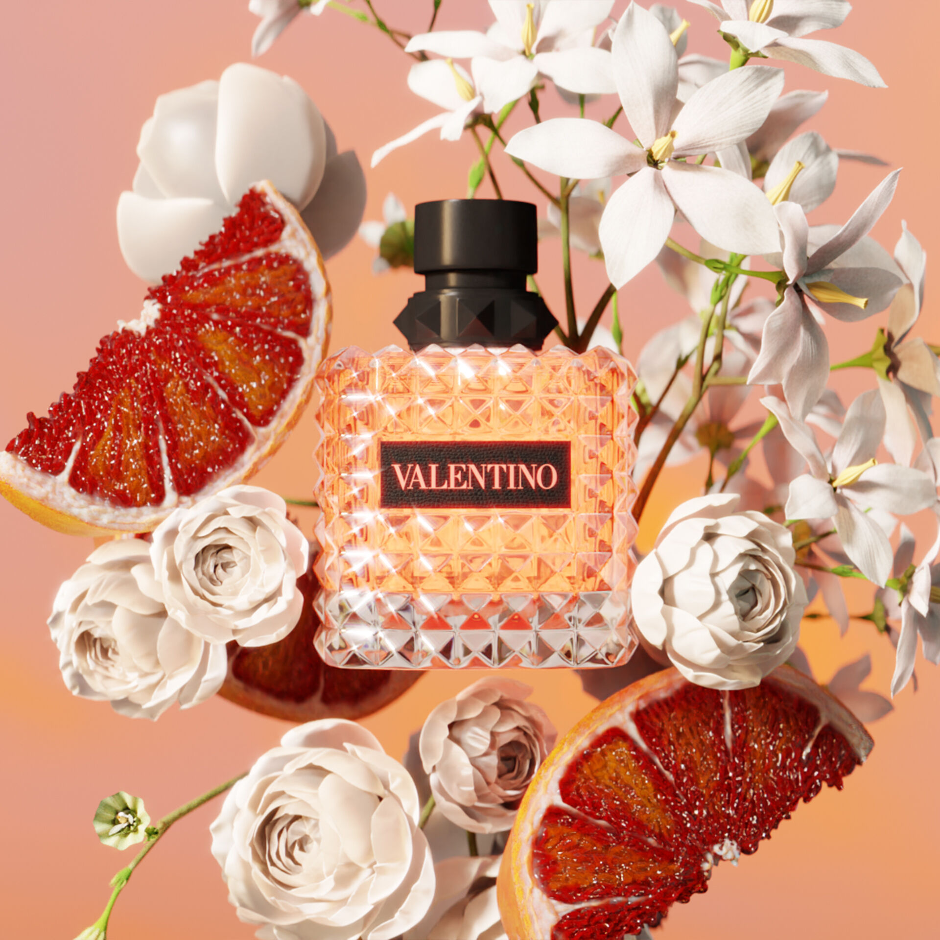 A sparkling bottle of Valentino perfume surrounded by fresh blood orange slices and white roses against a soft pastel background.