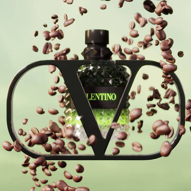 A stylized perfume bottle with a geometric design is framed by a black outline. Surrounding the bottle are scattered coffee beans, creating a dynamic, energetic feel against a soft green background. The bottle features bold text that reads "VALENTINO."
