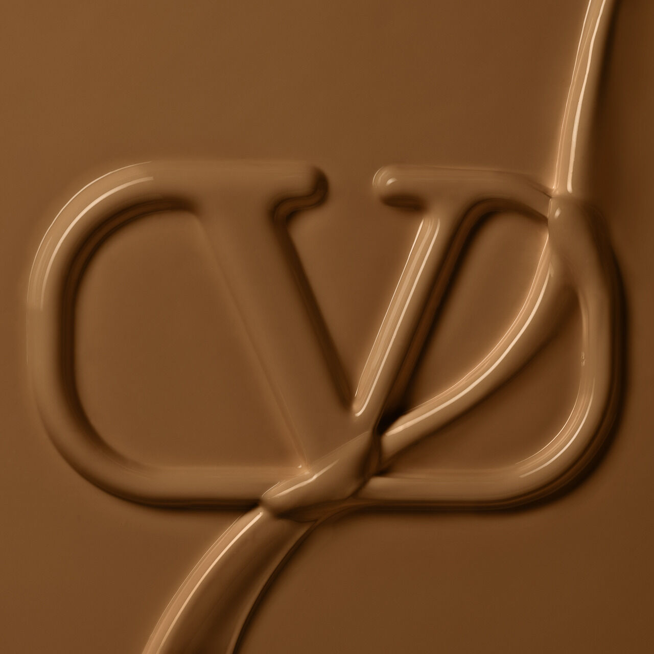 The image features a smooth, chocolate-like texture with a stylized logo subtly integrated into the design, resembling a blend of letters against a warm brown background.