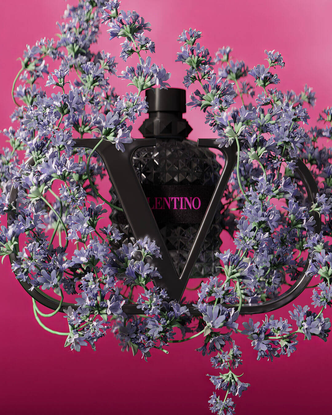 A black perfume bottle with a geometric design is surrounded by lush violet flowers, set against a vibrant pink background. The bottle features the name "Valentino" in bold pink lettering.