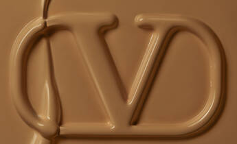 Close-up of a glossy, caramel-colored surface featuring a stylized "JD" logo embossed in the material.