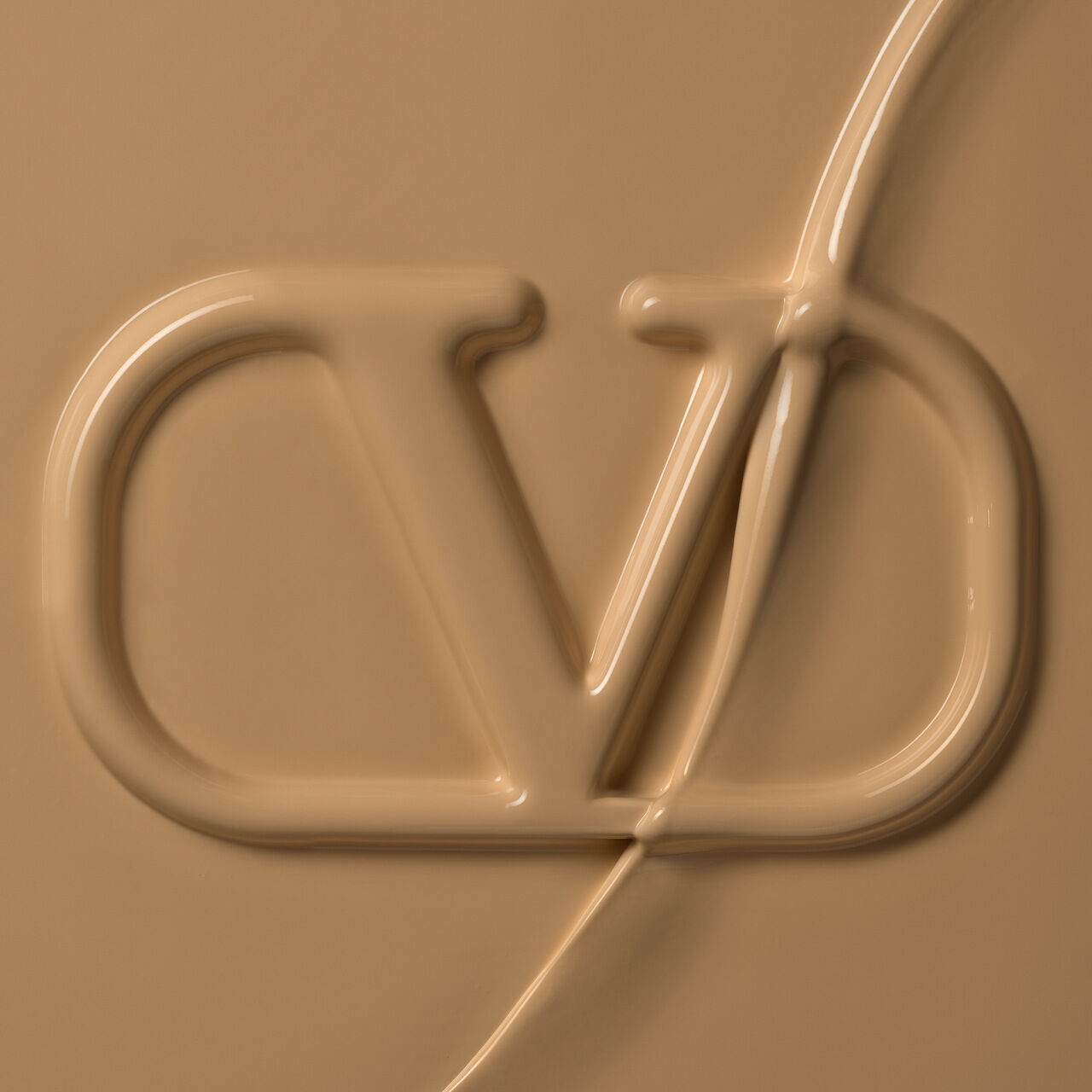 Close-up of a textured surface featuring a stylized logo, embossed in a creamy beige color.