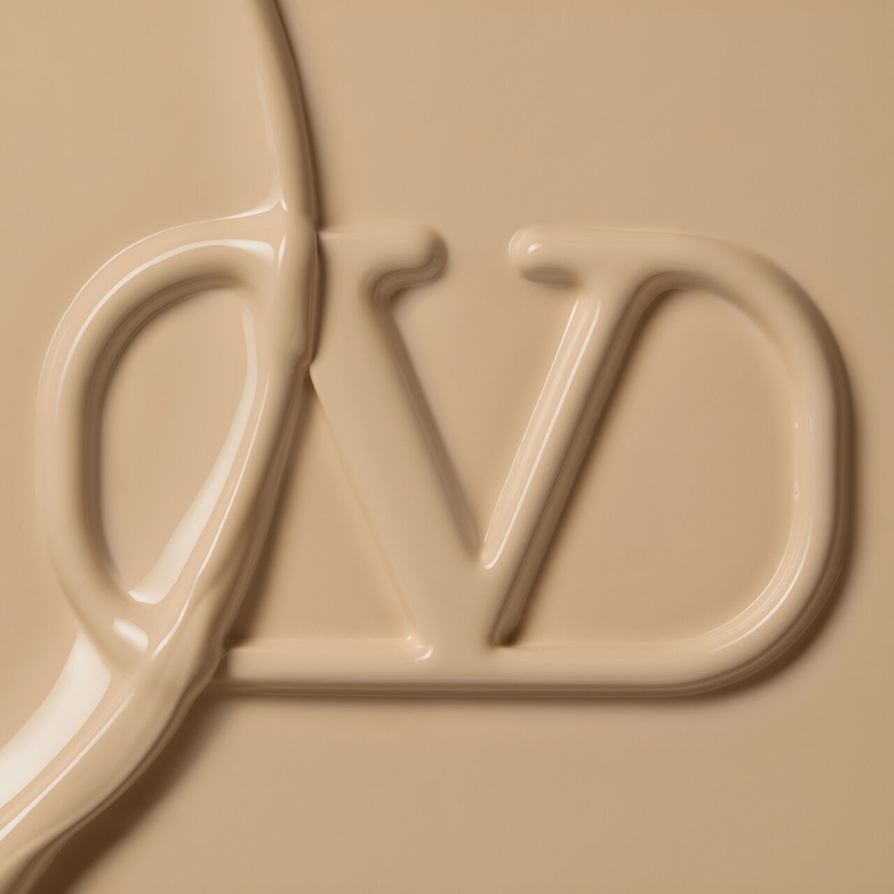 A close-up of a creamy, beige substance with the letters "VD" partially formed in a smooth texture.