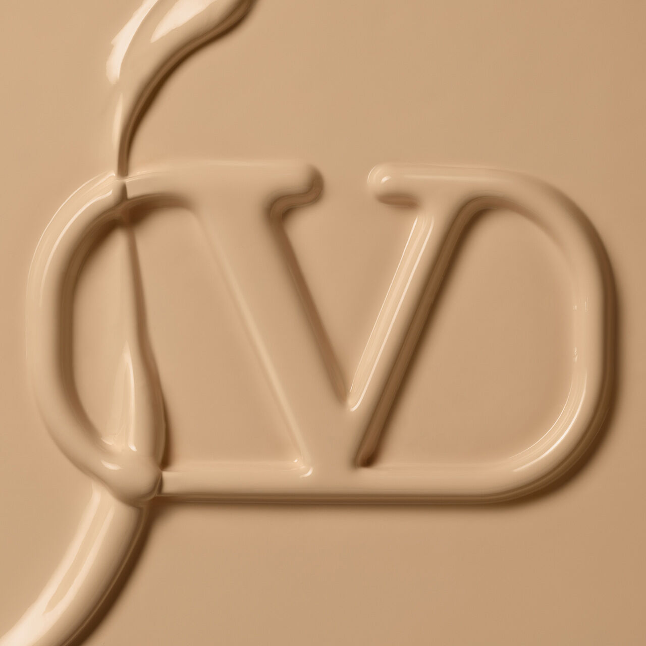 An abstract close-up of a creamy, beige substance forming the letters "JD" in a smooth, fluid style.