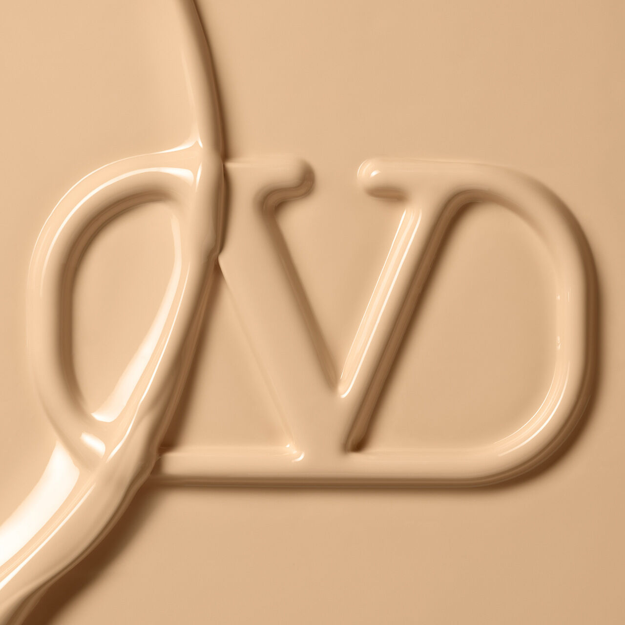 Close-up of a smooth, creamy texture forming the letters "DV" in a light beige color.