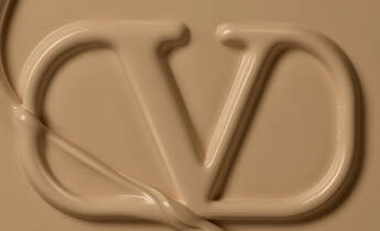 A close-up of a textured beige surface featuring the letters "V" and "D" elegantly formed from a cream-like substance.