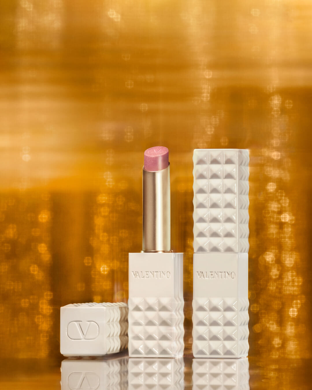 SPIKE VALENTINO IVORY placed against a backdrop of shimmering gold