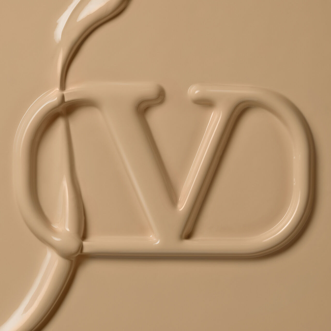 Close-up of a beige, creamy surface featuring an embossed logo with the letters "J" and "D."