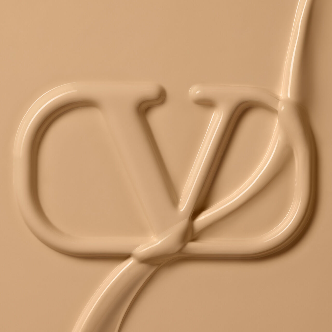 A smooth, creamy texture forming the letters "VD" in a light beige color.