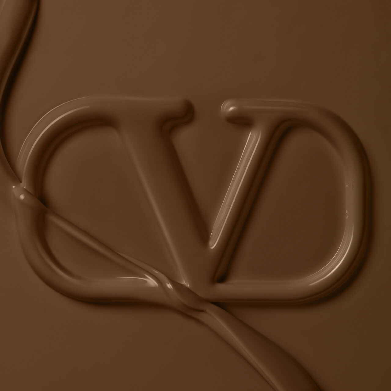 A smooth, rich chocolate background featuring an artistic, fluid representation of the letters "CD."