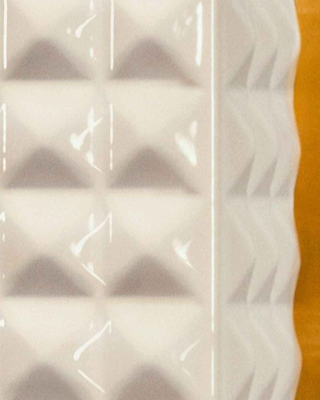 A woman wearing black lace-patterned gloves held a SPIKE VALENTINO IVORY, pressing the keys of a vintage telephone.